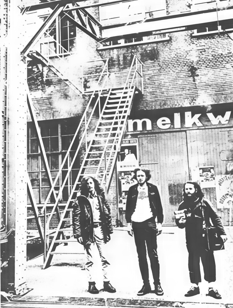 a photo of 3 men, one of them Jack, outside the Melkveg club in Amsterdam. Jack hlds a video camera. Probably during the 1970s.